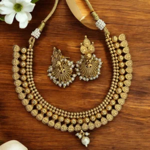 Temple-inspired gold-plated necklace set paired with matching pearl jhumka earrings